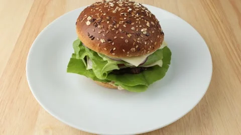 Delicious fresh hamburger with cheese rotating on a plate Stock Footage 345530302