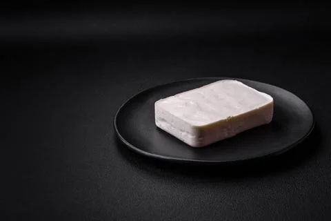 Delicious fresh rectangular shaped feta cheese with spices and vegetables Stock Photos