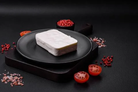 Delicious fresh rectangular shaped feta cheese with spices and vegetables Stock Photos