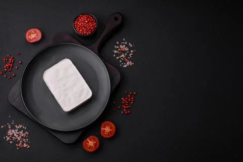 Delicious fresh rectangular shaped feta cheese with spices and vegetables Stock Photos
