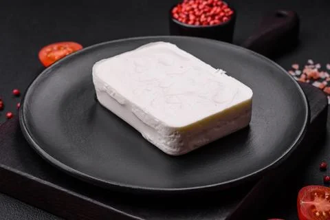 Delicious fresh rectangular shaped feta cheese with spices and vegetables Stock Photos