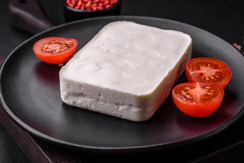 Delicious fresh rectangular shaped feta cheese with spices and vegetables Stock Photos