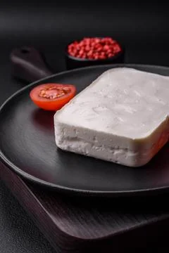Delicious fresh rectangular shaped feta cheese with spices and vegetables Fotos de archivo