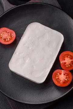 Delicious fresh rectangular shaped feta cheese with spices and vegetables Stock Photos