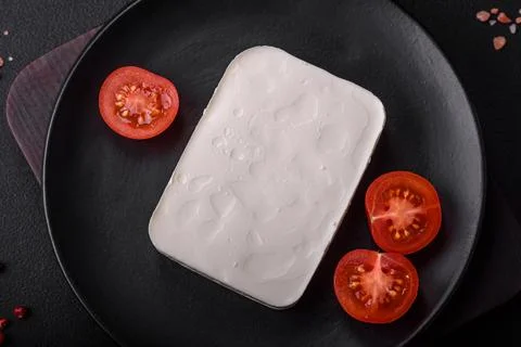Delicious fresh rectangular shaped feta cheese with spices and vegetables Stock Photos