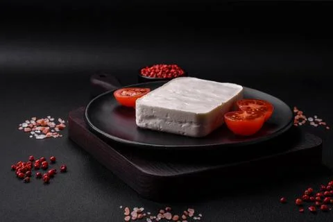 Delicious fresh rectangular shaped feta cheese with spices and vegetables Stock Photos