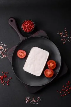 Delicious fresh rectangular shaped feta cheese with spices and vegetables Stock Photos