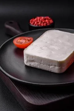 Delicious fresh rectangular shaped feta cheese with spices and vegetables ... Stock Photos