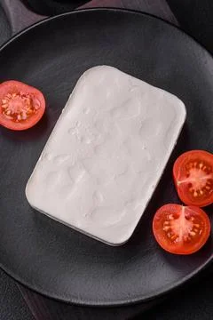 Delicious fresh rectangular shaped feta cheese with spices and vegetables ... Stock Photos