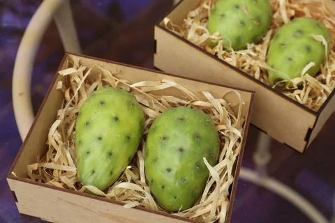Delicious fresh ripe opuntia fruits in boxes on wooden table Stock Photos