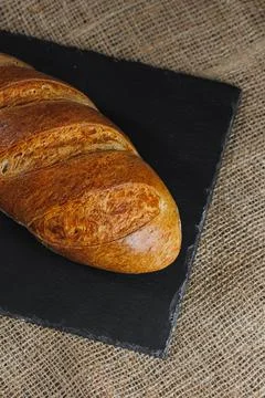Delicious fresh rye round bread on a dark background. Crispy fresh bread. Fre Stock Photos