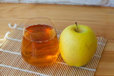 Delicious fresh squeezed apple juice in  transparent glass Stock Photos