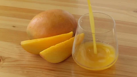 Delicious fresh squeezed mango juice in  transparent glass Stock Footage 129199197