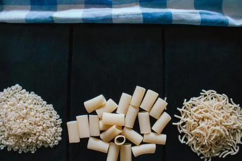 Delicious freshly made raw pasta prepared to be cooked. Fresh pasta on black  Stock Photos