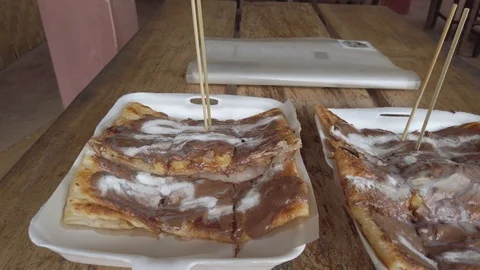 Delicious fried crepes with chocolate, coco, milk. Typical Lao street food Stock Footage 112159847