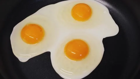 Delicious fried eggs sizzling in the pan. Concept of breakfast. Stock Footage 310826928