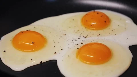 Delicious fried eggs sizzling in the pan. Concept of breakfast. Stock Footage 314819720