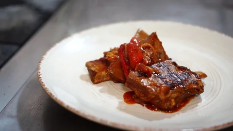 Delicious fried meat hot spicy pork ribs slices in tasty tomato sauce on white Stock Footage 106979288