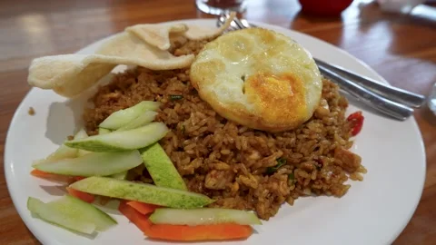 Delicious fried rice served with a fried egg, crackers, and fresh pickles. Stock Footage 340417567