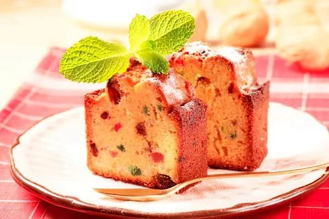 Delicious fruit cake with mint garnish on plate Stock Photos