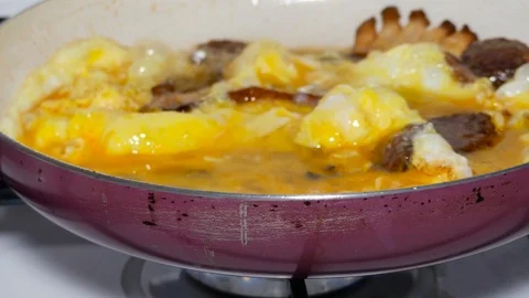 Delicious frying scrambled eggs for breakfast footage with bacon, sausage. Stock Footage 85546058