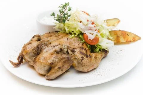 Delicious grilled chicken with a side dish of vegetables and herbs Stock Photos