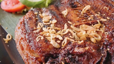 Delicious grilled fish served with crispy fried shallots and fresh vegetables. Video stock 343401325