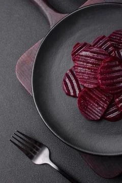 Delicious healthy boiled ruby-colored beets sliced ??on a black plate Stock Photos