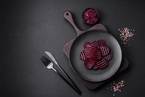 Delicious healthy boiled ruby-colored beets sliced ??on a black plate Stock Photos