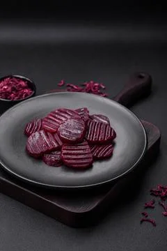 Delicious healthy boiled ruby-colored beets sliced ??on a black plate Stock Photos