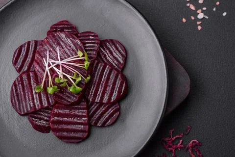 Delicious healthy boiled ruby-colored beets sliced ??on a black plate Stock Photos