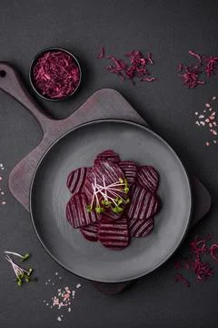 Delicious healthy boiled ruby-colored beets sliced ??on a black plate Stock Photos