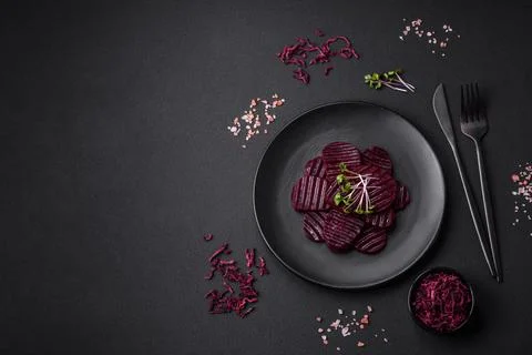 Delicious healthy boiled ruby-colored beets sliced ??on a black plate Stock Photos