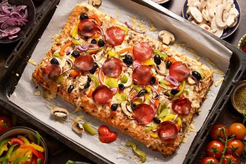 Delicious Homemade rectangular pepperoni pizza on a rustic table with 스톡 사진