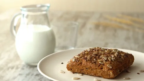 Delicious homemade small loaf of bread with seeds. Milk-jug, on wooden rustic Stock Footage 70789370