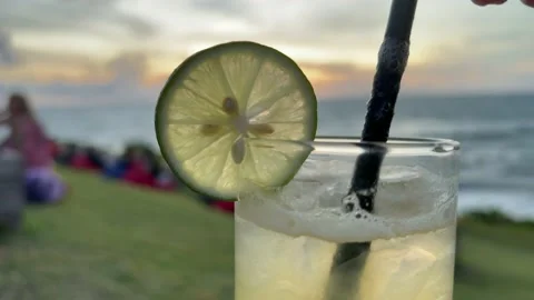 Delicious lime juice and vodka alcoholic cocktail on a beach at seaside Stock Footage 167593104
