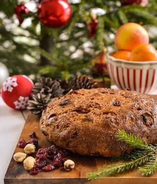 A delicious loaf of bread, festive decorations and set on a wooden surface. Stock Photos