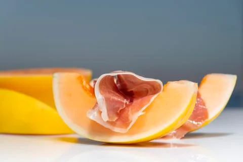 A delicious looking slice of melon with a cured ham slice on top, with out of Stock Photos