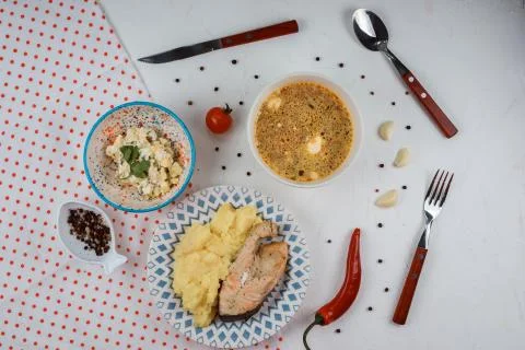 Delicious lunch set made of mashed potatoes and fish steak, soup and salad. Stock Photos