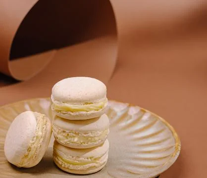 Delicious macarons on a plate in a simple setting at a kitchen table Stock Photos