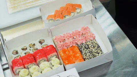 Delicious made sushi rolls packed in a white boxes and ready for sale to people. Stock Footage 119978960