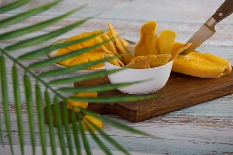 Delicious mango is cut with sharp knife, slices candied mango are laid Stock Photos
