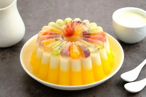Delicious Mango Milk Pudding with fruit topping. Served on white plate Stock Photos