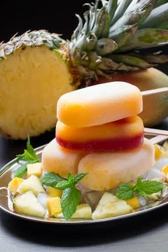 Delicious mango pineapple ice cream served on a silver platter with fresh fruit Stock Photos