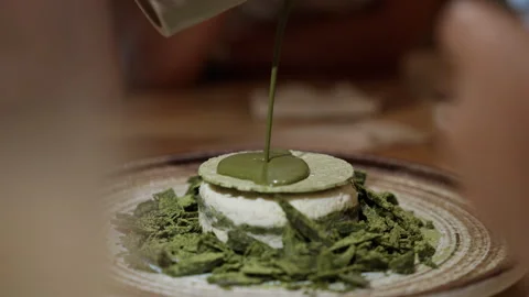 Delicious matcha cake being adorned with a drizzle of sticky, vibrant green Video stock 249713801