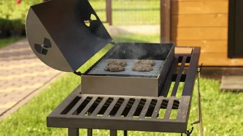 Delicious meat burger patties cooking on a charcoal barbecue grill during a.. Stock Footage 340237461