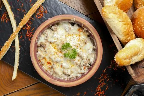 Delicious meat dish served with bread and snack items on a table Stock Photos