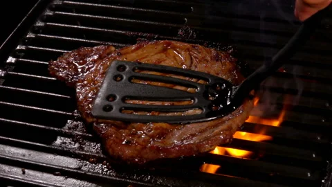 Delicious meat steak is pressed to the hot surface of the grill over Video stock 146590541