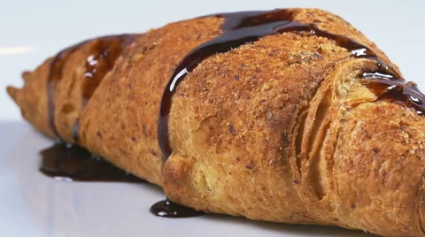 Delicious melted chocolate syrup covering a croissant in slow motion Stock Footage 59666108