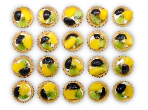Delicious mini fruit tart with peach, grape & kiwi, line up and view from top Stock Photos